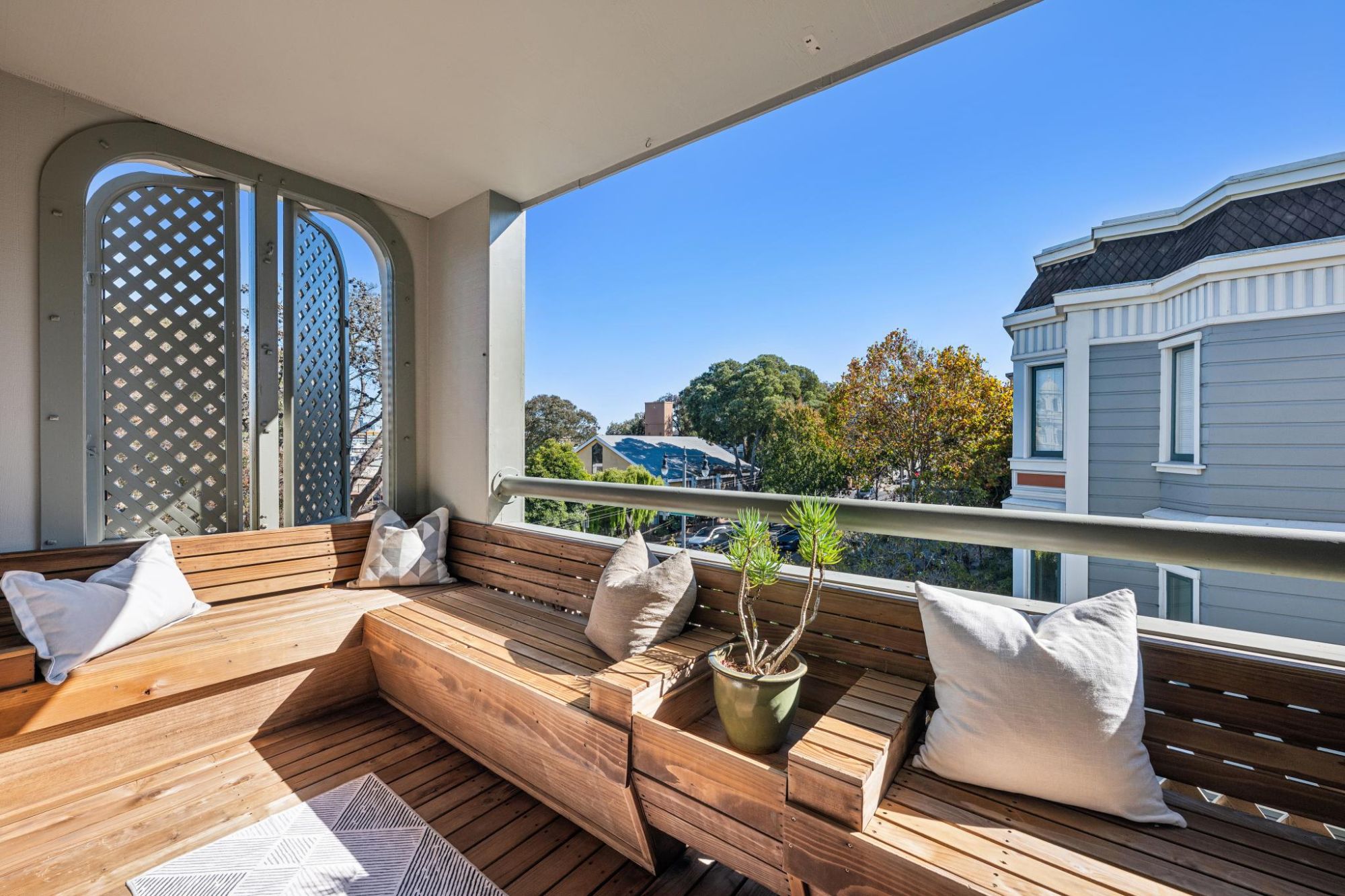 Private balcony with built-in wood benches and a view over the trees