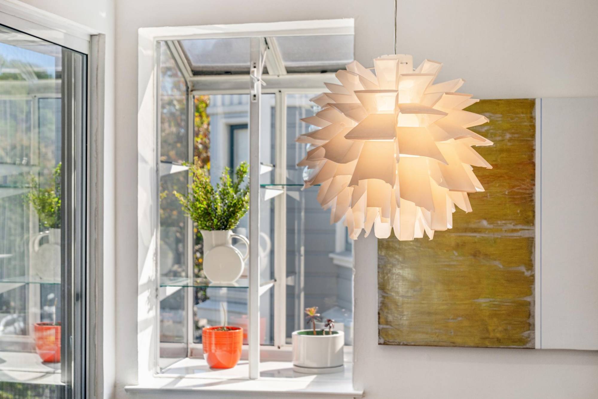 Pendant light beside a sunny garden window with plants