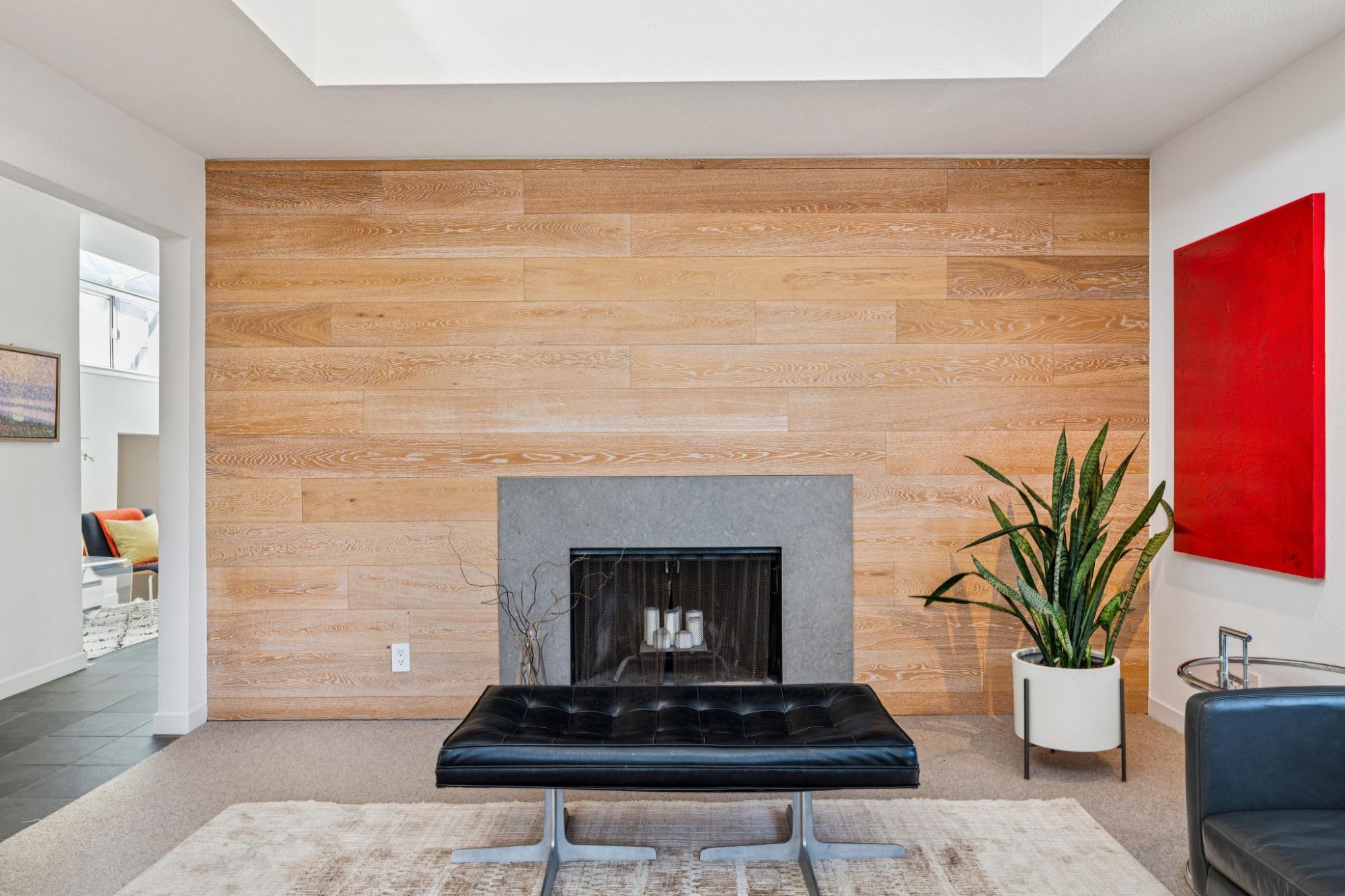 Wood-burning fireplace set in a white oak plank wall