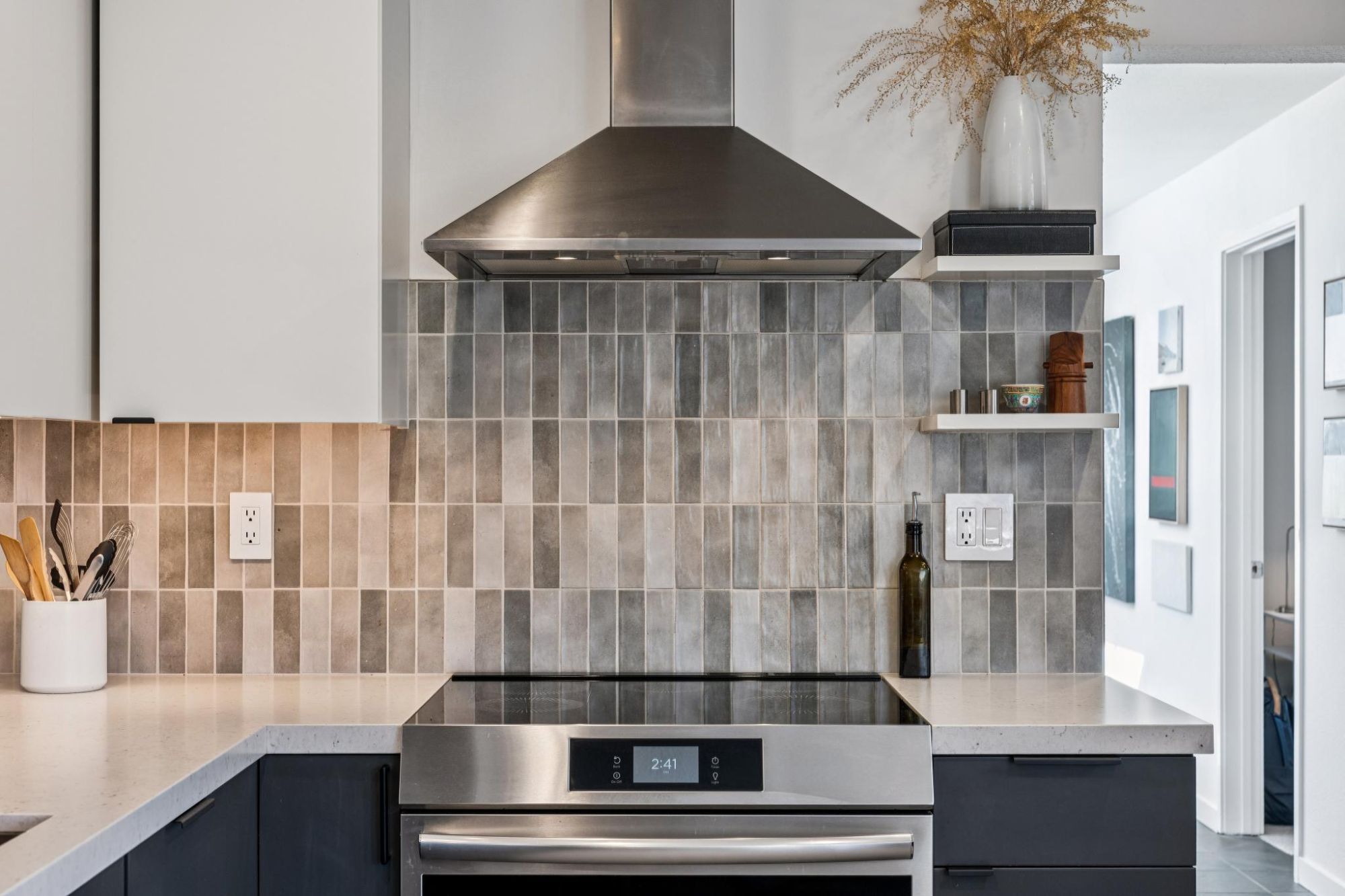 Updated kitchen with induction range, stainless hood and handmade-look tile backsplash