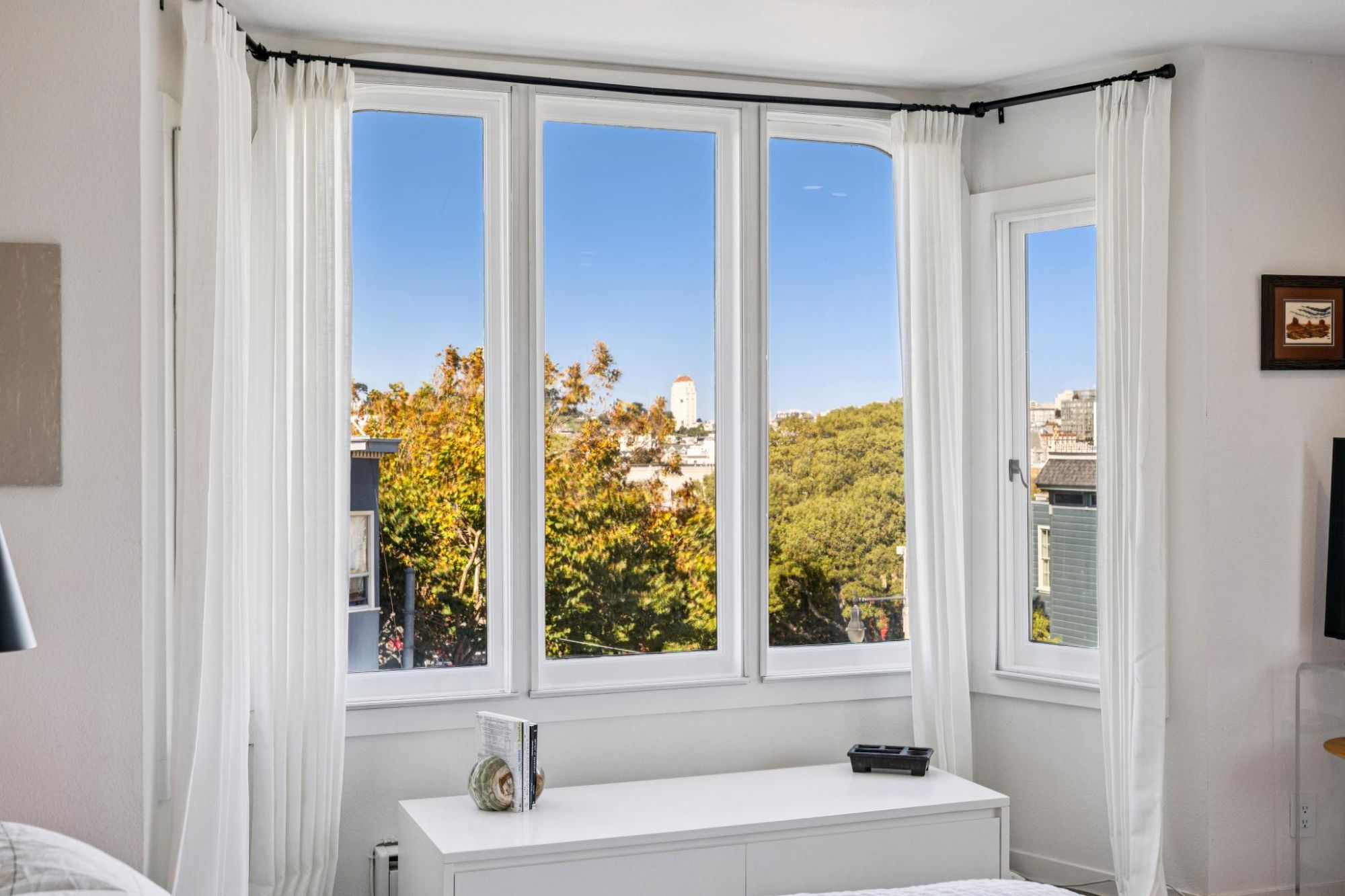 Bay window in the primary bedroom looking over treetops